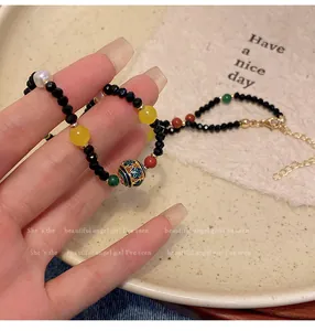 Detailansicht eines bunten Kristallperlen-Chokers mit einer verzierten Emaille-Glücksperle
