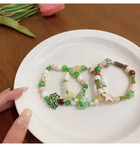 Vista detallada de tres pulseras de cuentas de cerámica color macaron con dijes lindos