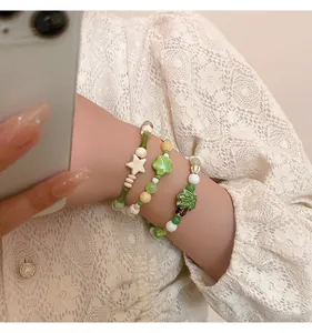 Primer plano de pulseras de cuentas de cerámica macaron en la muñeca con ropa de encaje