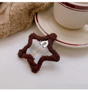 Detailed close-up showing the cozy texture of a brown knitted star hair clip for autumn/winter