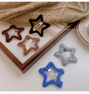 Close-up view of five colorful woolen star-shaped hair clips for the autumn and winter seasons