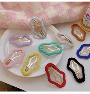 Detailed display of various colorful cloud-shaped knitted hair clips on a white ceramic plate