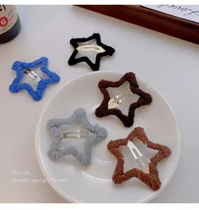 Close-up showing various colorful woolen star-shaped hair clips on a white plate.