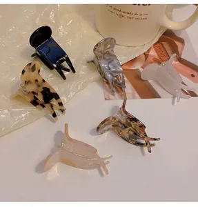 Set of small aesthetic hair claw clips in tortoiseshell and marble patterns for styling.