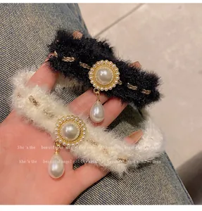 Détail de ras-du-cou en peluche noir et blanc avec d'élégants pendentifs en perles