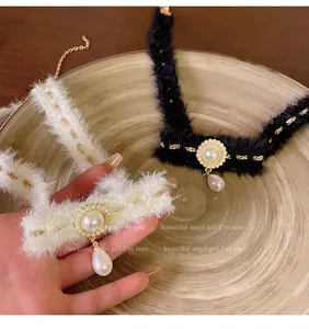 Gros plan de colliers ras-du-cou de luxe en peluche avec perles et pendentifs goutte