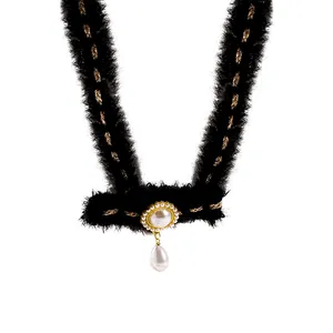 Collier choker élégant en peluche noire avec tissage doré et pendentif de perle.