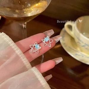 Silver star-shaped stud earrings with light blue accents for a dainty aesthetic look.