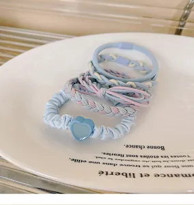 Macro shot of assorted pastel blue and pink dopamine hair ties on a white plate