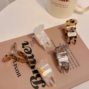 Set of mini marble and tortoiseshell hair claw clips for high ponytail styles.