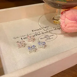 Elegant pink and blue butterfly stud earrings featuring a shimmering cat-eye stone effect