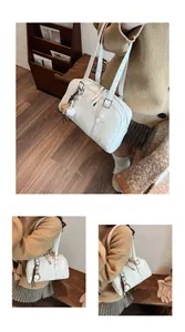 White large-capacity tote bag detail showing shoulder strap and baseball charm