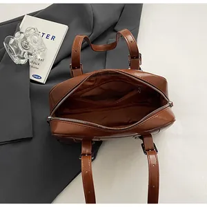 Internal view of a large brown leather tote bag showing spacious lining and zip pocket.