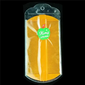 Detailed view of a yellow fine-tooth nit comb for scalp care in clear plastic packaging
