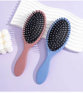 Detailed view of two Morandi color oval cushion hairbrushes on purple background