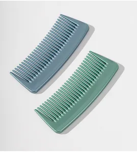Vue détaillée de peignes démêlants portables bleu et vert sur une surface blanche.