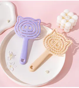 Detail view of cute pig-shaped hollow scalp massage hairbrushes in purple and beige