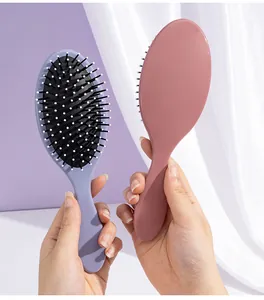 Detailed view of Morandi-colored oval cushion hairbrushes with soft massaging bristles.