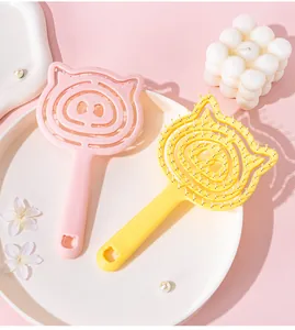 Detailed macro shot of cute pig-shaped hollow scalp massage combs in pink and yellow colors