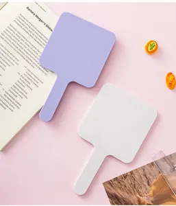 Dettaglio di specchietti quadrati portatili nei colori lavanda e bianco con manico