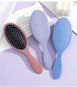 Detail view of colorful pastel detangling hair brushes on creative background