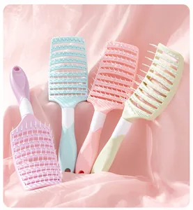 Macro view of pastel-colored vented hair brushes on elegant soft pink silk fabric background