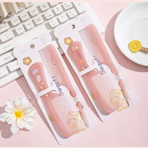 Detailed close-up of a pink cartoon hair comb set in cute packaging on a pink desk