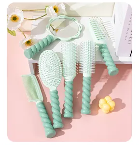 Detailed shot of a mint green hair brush set featuring stylish twisted ergonomic handles