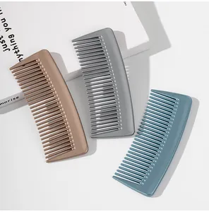 Lot de trois peignes à cheveux portables à dents larges en marron, gris et bleu de voyage.