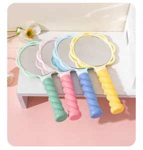 Close-up of flower-shaped handheld mirrors with pastel spiral handles