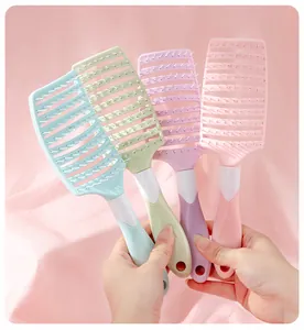 Detail view of four ergonomic vented hair brushes in pastel shades held by hands for styling