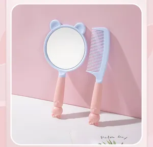 Close-up detail of the cute pink and blue cat-themed hand mirror and matching hair comb