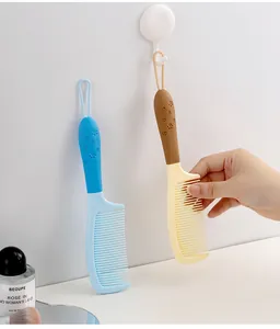 Peigne à cheveux portable avec poignée en silicone à empreinte de patte et boucle de suspension.