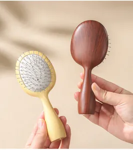 Detailed view of two portable wooden texture cushion hairbrushes with steel pins