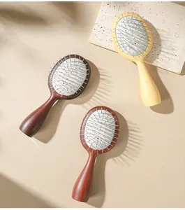 Detailed view of oval hairbrushes with steel pins on a textured stone surface