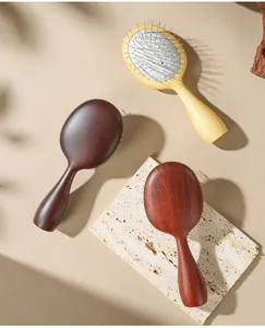 Detailed view of wood grain massage hairbrushes with steel pins on stone base