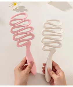Close-up of pink and beige wavy hollowed-out ribbon styling hairbrushes for women