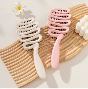 Detail view of hollow wavy hairbrushes with boar bristles on a wavy wooden tray surface