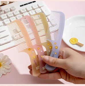 Detail shot of three pastel-colored mini hair combs with cute floral and cartoon prints.