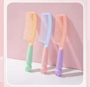 Close-up of three colorful cat-themed hair combs in pastel mint, pink, and purple.