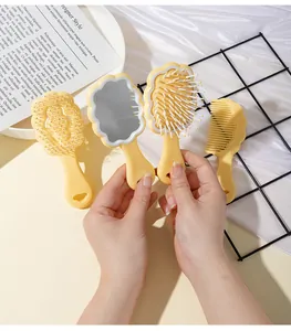 Cute yellow cloud-shaped air cushion hair brush and vanity mirror set held by a hand