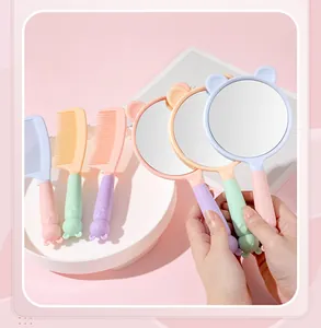Detailed macro view of cute pastel cat-ear hand-held makeup mirrors and matching hair combs set