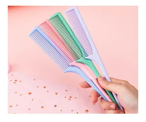 Hand holding four colorful plastic rat tail combs for hair styling and sectioning.