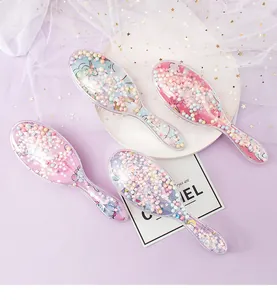 Detail of transparent hairbrushes filled with colorful beads and cartoon unicorn prints.