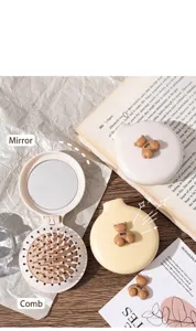 Vista detallada de un mini peine de espejo plegable portátil con linda decoración de oso 3D