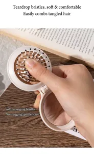 Detalle de las púas de masaje suaves de un cepillo de pelo plegable blanco con espejo