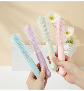 Close-up view of four pastel cat paw round hair brushes being held in hands for detail
