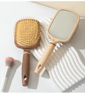 Vue détaillée de la brosse à cheveux miroir beige et de la brosse de massage brune