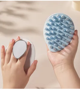 Detail view of a leaf-shaped silicone scalp massage brush with ergonomic finger handle