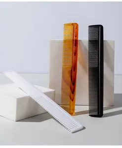 Close-up of professional plastic fine-tooth hair styling combs in white, amber, and black.